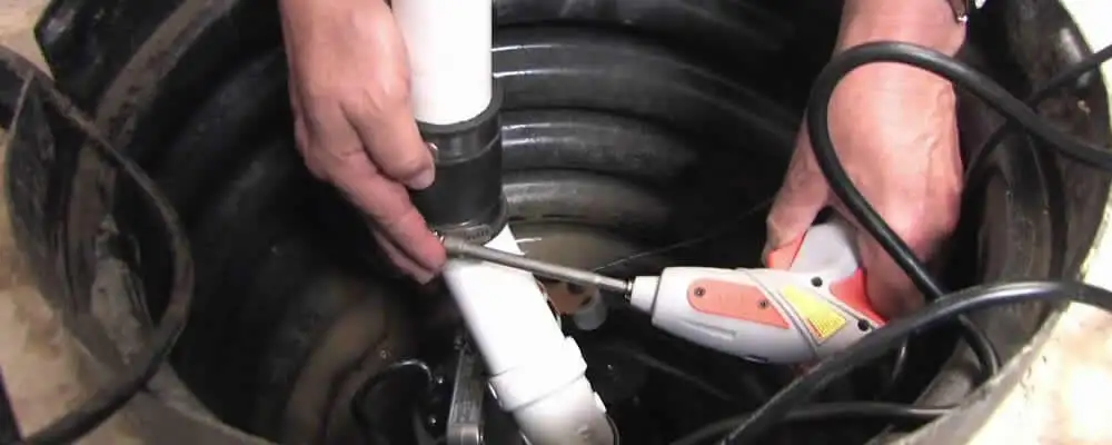 Sump pump installation technician connecting PVC discharge piping in Fort Lauderdale, FL